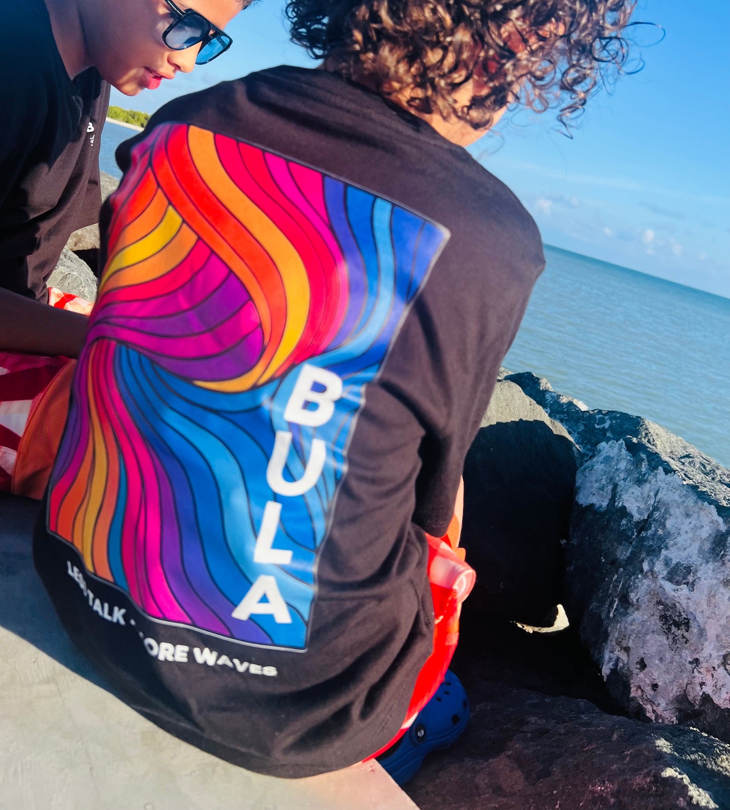 BULA “Less Talk • More Waves” 🌊

Este verano vístete de BUENA ENERGÍA con nuestra camiseta exclusiva BULA WAVES. Diseño vibrante inspirado en el movimiento de las olas y los colores del atardecer tropical, esta pieza combina comodidad y personalidad.